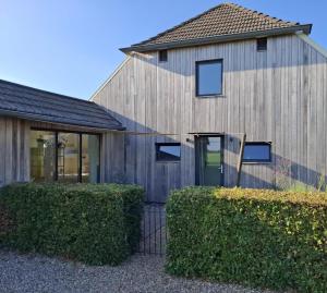 Baak't Holtslag的前面有灌木丛的木屋