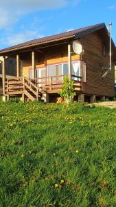 马里瑟尔Casuta de Vacanta Marisel, Cluj的带门廊和草坪的木屋