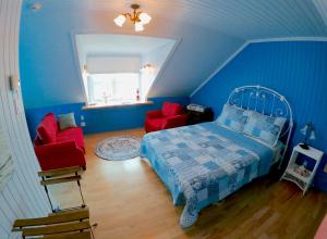 里穆斯基Chez Caro et Sylvain的蓝色卧室,配有床和两张红色椅子 更多16张照片