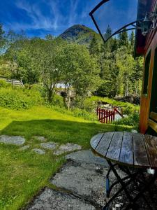 ein Picknicktisch in einem Hof mit Bergen im Hintergrund in der Unterkunft Haukedalen mountain panorama river view in Holsen + 8 Fotos