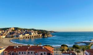 a view of a beach with houses and the ocean at Vue Panoramique Exceptionnelle Mer, Montagne et Village l T2 Luxueux in Banyuls-sur-Mer