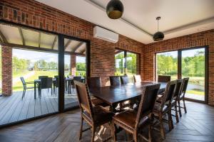 a dining room with a brick wall and a table and chairs at Galuonų vilos in Inturkė