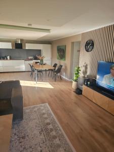 a living room with a table and a tv in it at Kristiansand Mosby1 in Kristiansand