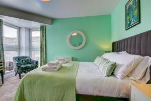 a bedroom with a bed and a chair and a mirror at River Ayr View-Coorie Doon Stays in Ayr
