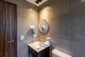 un baño con lavabo y espejo en CIERVO - Departamento céntrico, en Villa La Angostura 31 fotos más