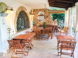 a patio with wooden tables and chairs and a stone wall at Casale Degli Angeli in Vieste