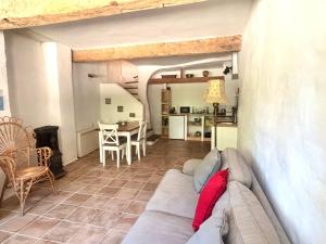 a living room with a couch and a kitchen at Logement entier dans les Corbières in Coustouge +13 photos
