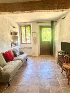 a living room with a couch and a television at Logement entier dans les Corbières in Coustouge