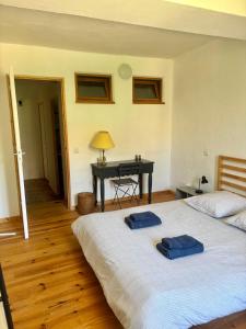 a bedroom with a bed with two blue towels on it at Logement entier dans les Corbières in Coustouge