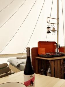 哈泽斯沃德多普Voedselbos Camping Koperwiek的帐篷内的桌子上一瓶葡萄酒