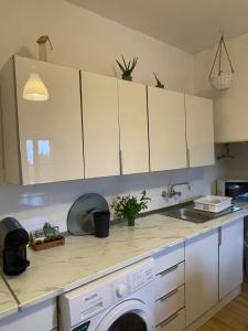 a kitchen with white cabinets and a washing machine at Casa na Quinta in Elvas