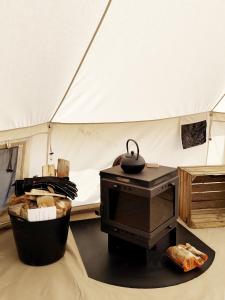 哈泽斯沃德多普Voedselbos Camping Koperwiek的房间中间有一个带炉子的帐篷
