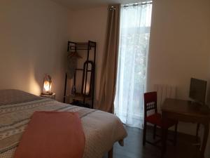 Un dormitorio con una cama y un escritorio y una ventana. en COSY CHIC - STAYHOME - Appart 2, en Quimper