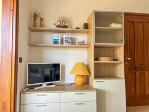 a room with a desk with a television and a lamp at Casa Marika in Murta Maria