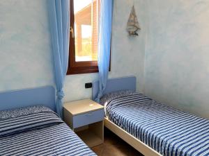 two twin beds in a room with a window at Casa Marika in Murta Maria