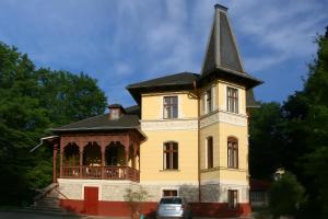a yellow house with a steeple on top of it at Seeappartements Excelsior in Velden am Wörthersee