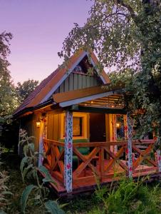 a tree house with a porch and a fence at Happy Hippy Cabin for 4 persons in Gataučiai