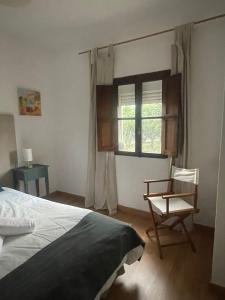 a bedroom with a bed and a chair and a window at Casa na Quinta in Elvas +24 photos