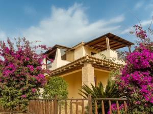 a house with pink flowers in front of a fence at Casa Marika in Murta Maria