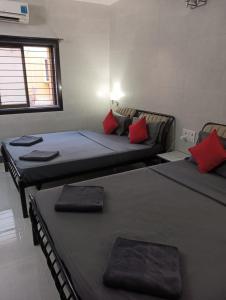 2 camas en una habitación con almohadas rojas en Sorted Stays, en Calangute 11 fotos más