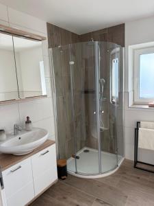 a bathroom with a shower and a sink at SUNSET RESIDENCE Attersee  +26 photos