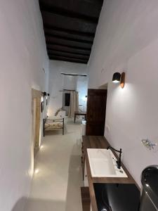 a bathroom with a sink and a bed in a room at Katharsis Palace 15th Century Art Hotel at Naxos Old Town IV in Naxos Chora