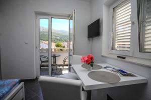 a room with a table and chairs and a balcony at Apartments Nevistic in Podstrana