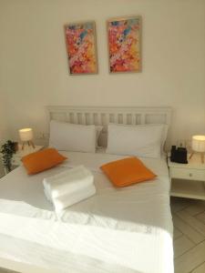 a white bed with two orange pillows on it at Cozy Apartment with Private Beach, couples and families only in Aqaba