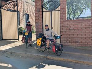 two men sitting on their bikes on a sidewalk at LA CASA DE RICKY "El balcón de las Montañas" in Caraz