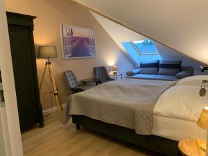 a bedroom with a bed and chairs in a attic at Dworek Pod Wierzbami in Wołuszewo