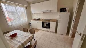 kuchnia ze stołem i białą lodówką w obiekcie Apartamento marinero w mieście Malpica