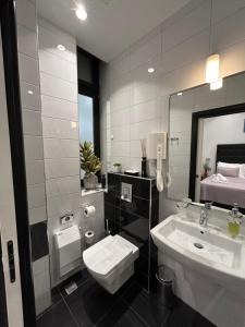 une salle de bain avec un lavabo, des toilettes et un miroir dans l'établissement Tango Rooms, à Split