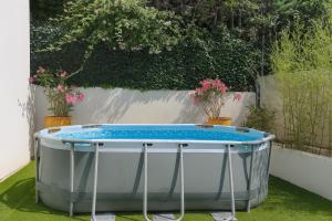 a bath tub sitting on the grass with plants at Maison, Jardin, piscine parking près d'Aix Centre in Venelles