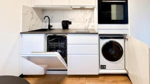 una cucina bianca con lavatrice e asciugatrice di Apartament Cichy na parterze Mrągowo a Mrągowo