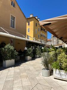 un patio avec des plantes en pot et un bâtiment dans l'établissement Tango Rooms, à Split