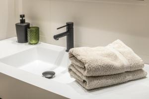 ein weißes Waschbecken mit Handtüchern darauf in der Unterkunft Las Suites de Platería in Murcia