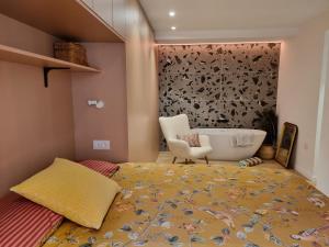 ein Schlafzimmer mit einem Bett und einem Stuhl und einer Badewanne in der Unterkunft Las Suites de Platería in Murcia