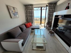 a living room with a couch and a glass table at Millenium II B34 in Sveti Vlas