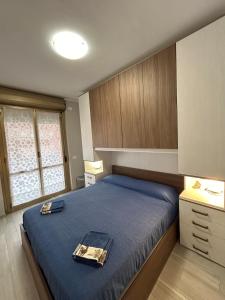 マリーナ・ディ・アンドーラにあるBilocale moderno Marina di Andoraの青い掛け布団が敷かれたベッドのある寝室