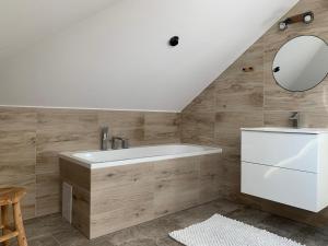 a bathroom with a white tub and a mirror at Dworek Pod Wierzbami in Wołuszewo +97 photos