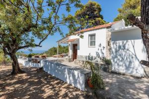 a white house with a tree in front of it at Bleu & Vert in Skopelos Town