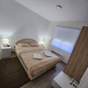 una camera da letto con un letto con due asciugamani sopra di Apartman Planinski Raj a Žabljak