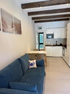 a living room with a blue couch and a kitchen at Cervia Mare in Cervia +7 photos