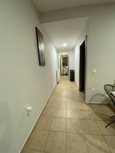 - un couloir avec des murs blancs et du carrelage dans l'établissement Anna's apartment, à Ayiá