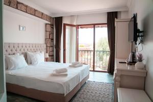 a bedroom with a large white bed with a balcony at Albeon Luxury Hotel - Alacatı in Alaçatı +64 photos