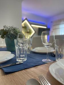 a table with glasses and plates on a blue napkin at Montijo Lux & Design Apartment - Private Rooms in Montijo
