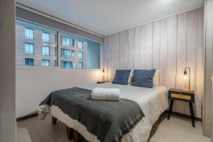 um quarto com uma cama grande e uma janela grande em Corazón Stgo Estilo Puro em Santiago