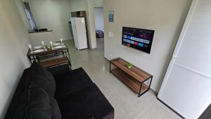 a living room with a couch and a refrigerator at Spazio Italia Apartamentos - Você entre a Lagoa e a Praia in Ilha Comprida