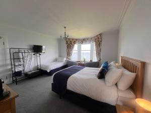 a bedroom with a bed and a couch and a window at Ronebhal Guest House in Oban
