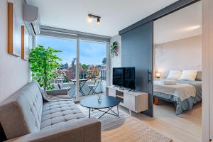 uma sala de estar com um sofá, uma cama e uma televisão em Corazón Stgo Estilo Puro em Santiago